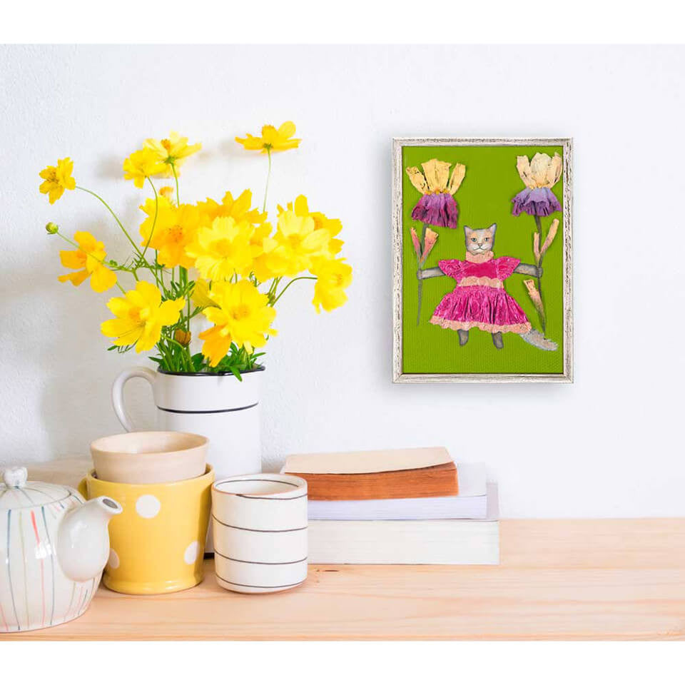 This whimsical cat in a pink dress, holding two flower stems, is a true conversation starter and makes a great addition to any décor.