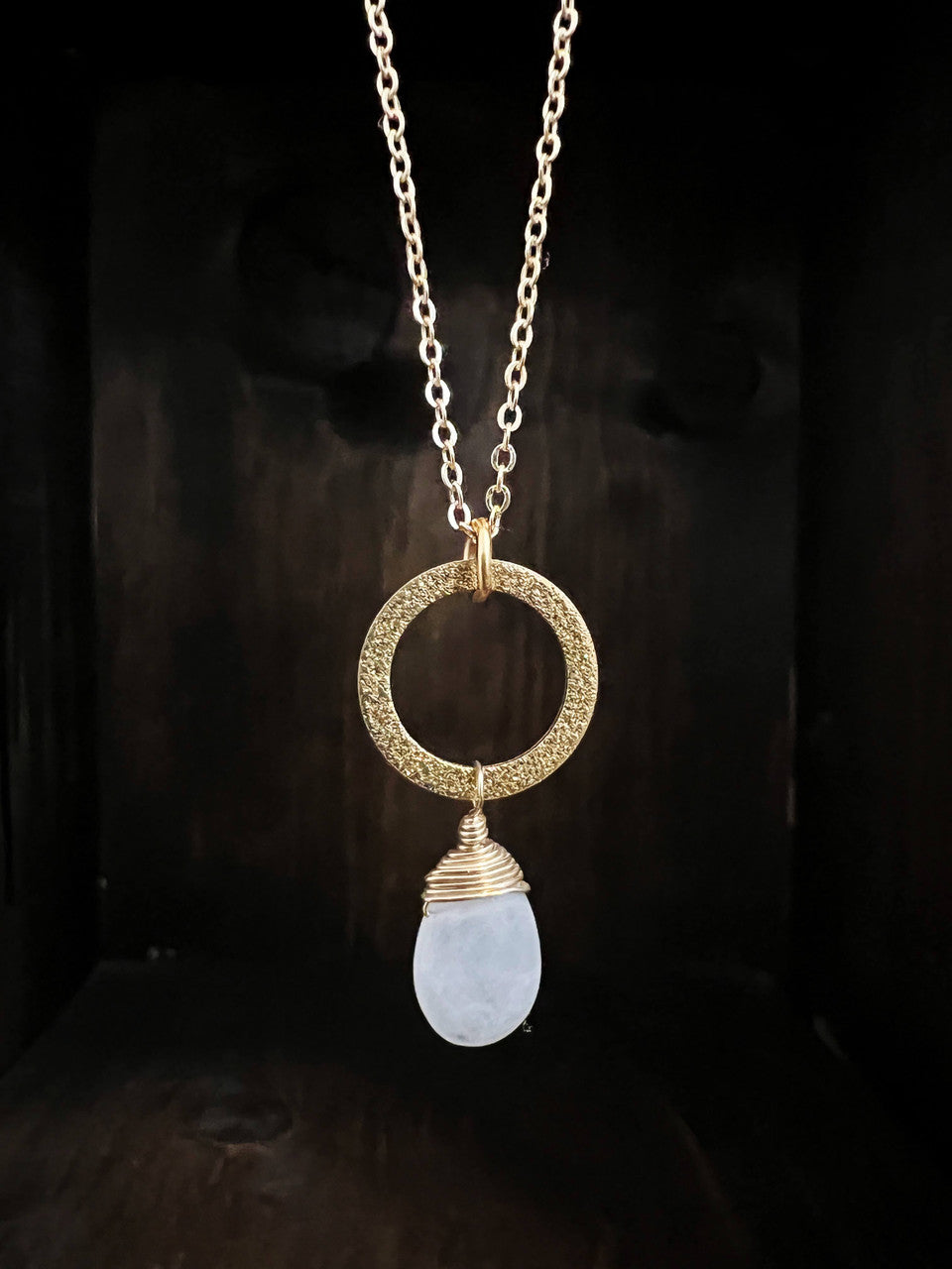 Moonstone drop with gold filled wire work on a stardust textured brass ring hanging on an 18” dainty brass chain with a gold filled spring ring clasp.