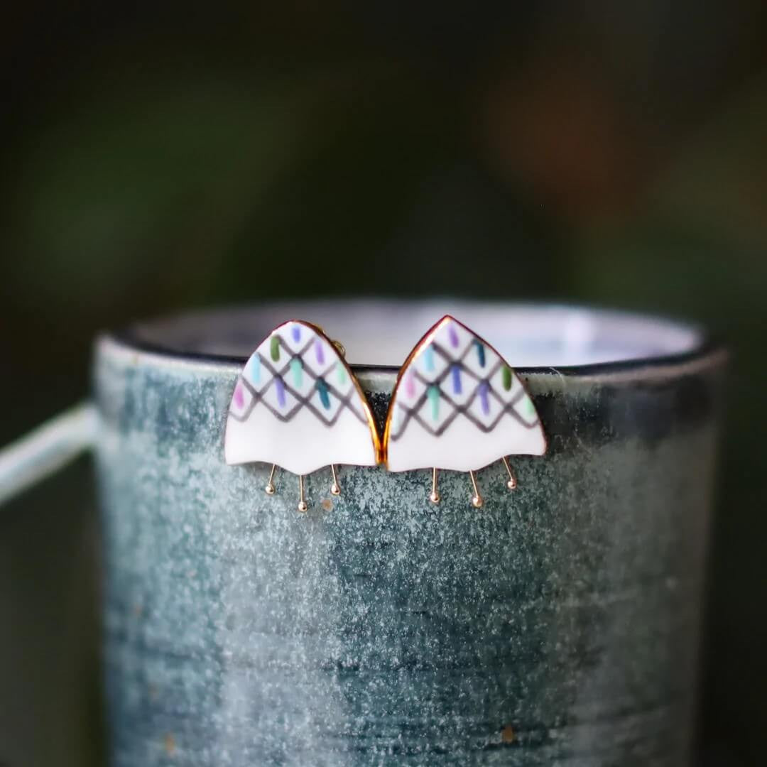 These fun floral earrings are hand shaped and painted with glazes and a 22k gold luster. 

Remnant Studios jewelry is handcrafted one piece at a time in Austin, Texas.