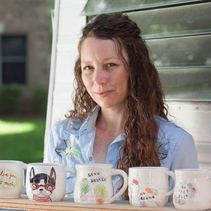 Get to Know the Austin Artist:
 Working in her south Austin home studio, she creates whimsical ceramics and paintings that celebrate positivity and her quirky love of pets and creatures. In addition to art she also plays music with her fam.